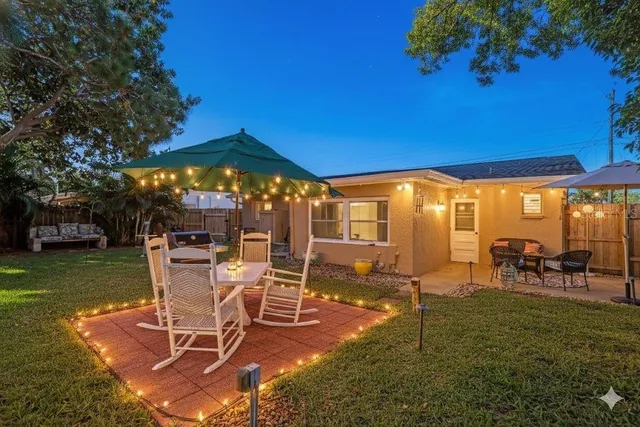 a view of a chairs and table in patio with a yard