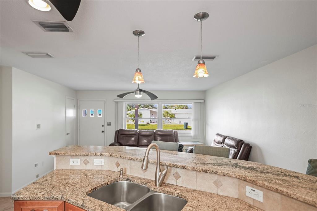 1215 Lazy Lake Road East Dunedin, FL 34698 - Photo 6 of 46 a kitchen with a faucet a chandelier