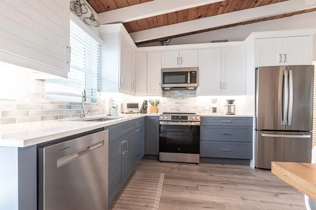 a kitchen with granite countertop a refrigerator stove and sink