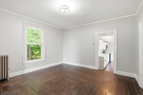 an empty room with wooden floor and a window