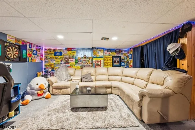 a living room with furniture a rug and gym equipment