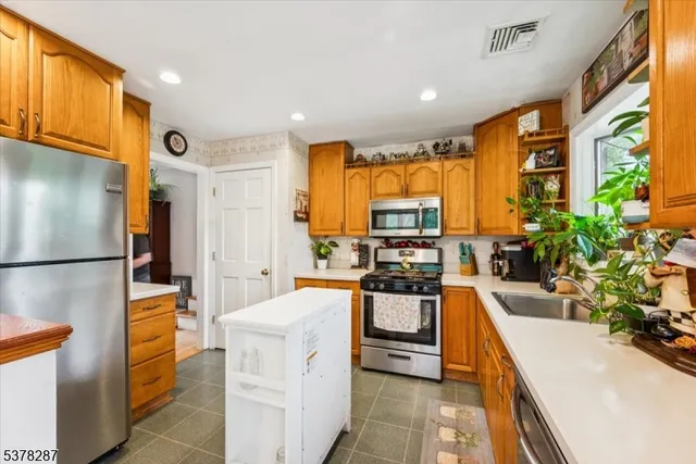 a kitchen with stainless steel appliances a sink a counter top space cabinets and a refrigerator