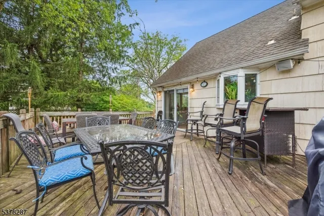 a view of a patio with table and chairs with wooden floor and fence