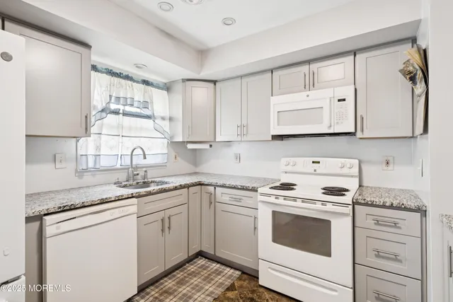 a kitchen with stainless steel appliances granite countertop white cabinets stove a sink and dishwasher