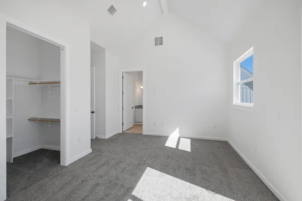 a view of a room with a chandelier fan and windows