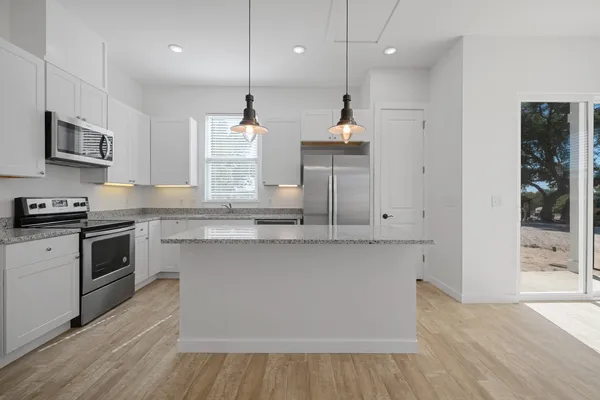 a view of a kitchen with wooden floor and a window