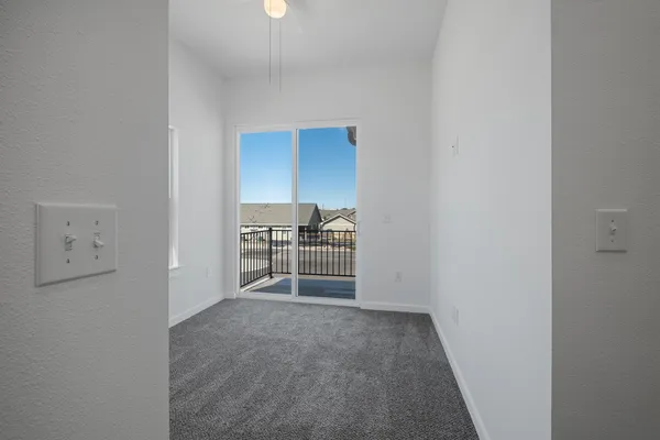 a view of a hallway with wooden floor and a bathroom
