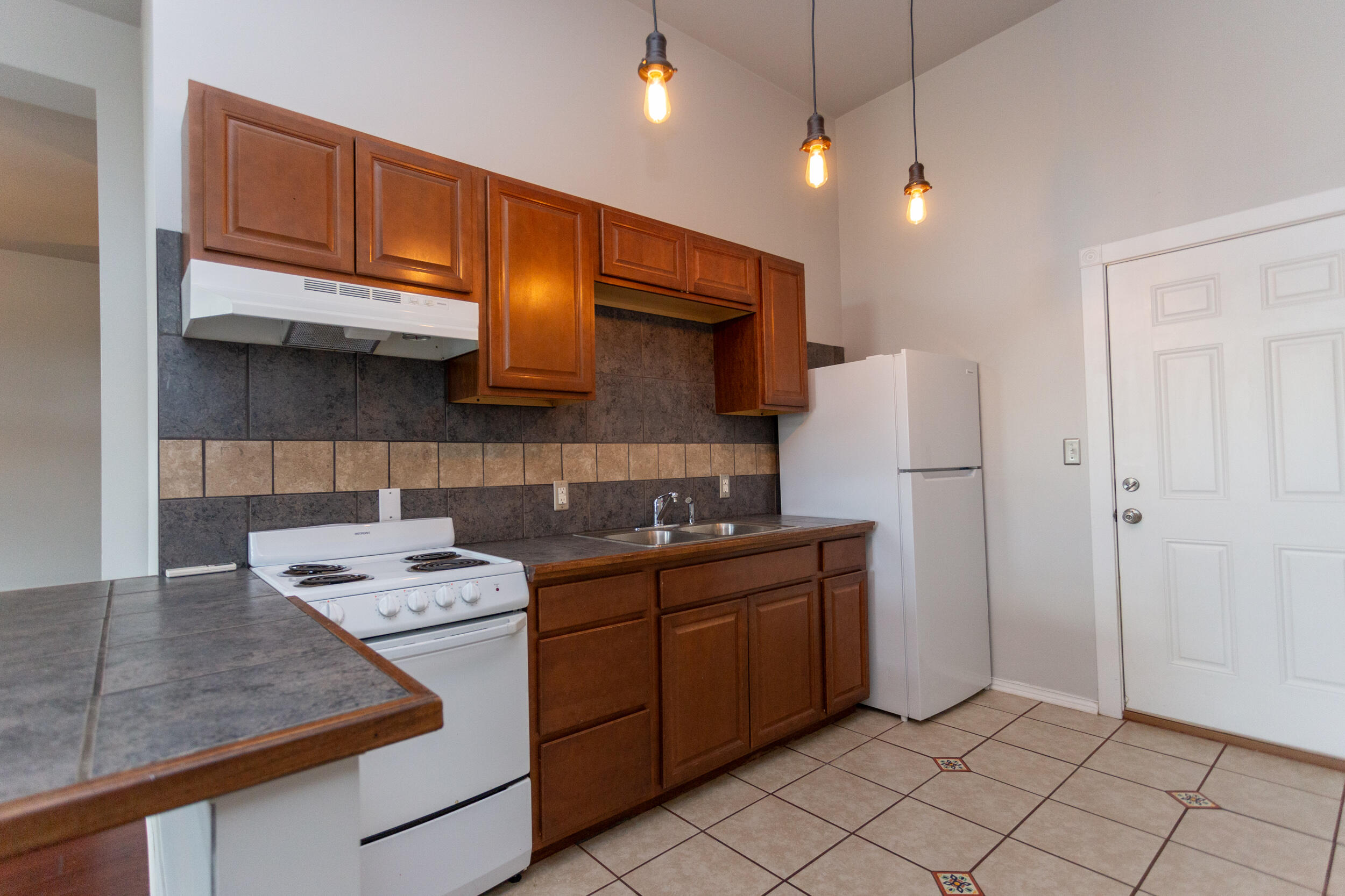 525 Franklin Street, Unit 7 Michigan City, IN 46360 - Photo 3 of 14 a kitchen with a sink a refrigerator and cabinets