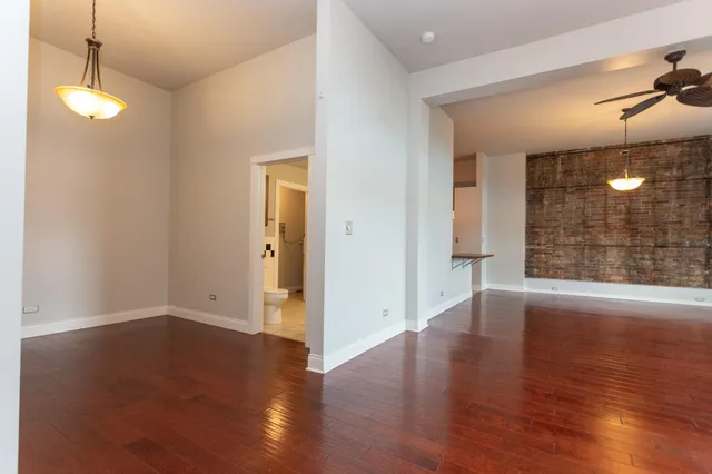 a view of a room with wooden floor and fan