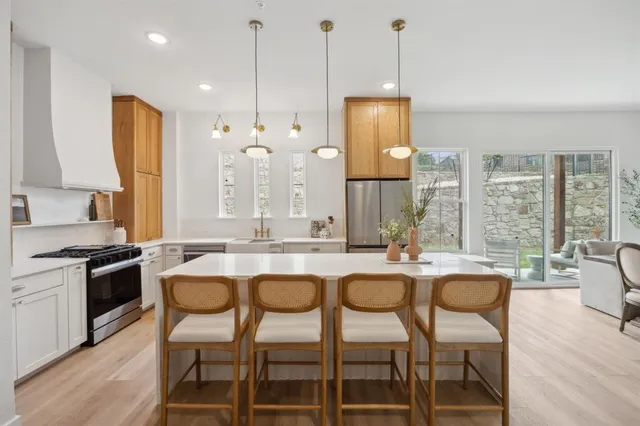 a kitchen with granite countertop wooden cabinets and a stove
