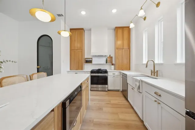 a large kitchen with a large window and stainless steel appliances