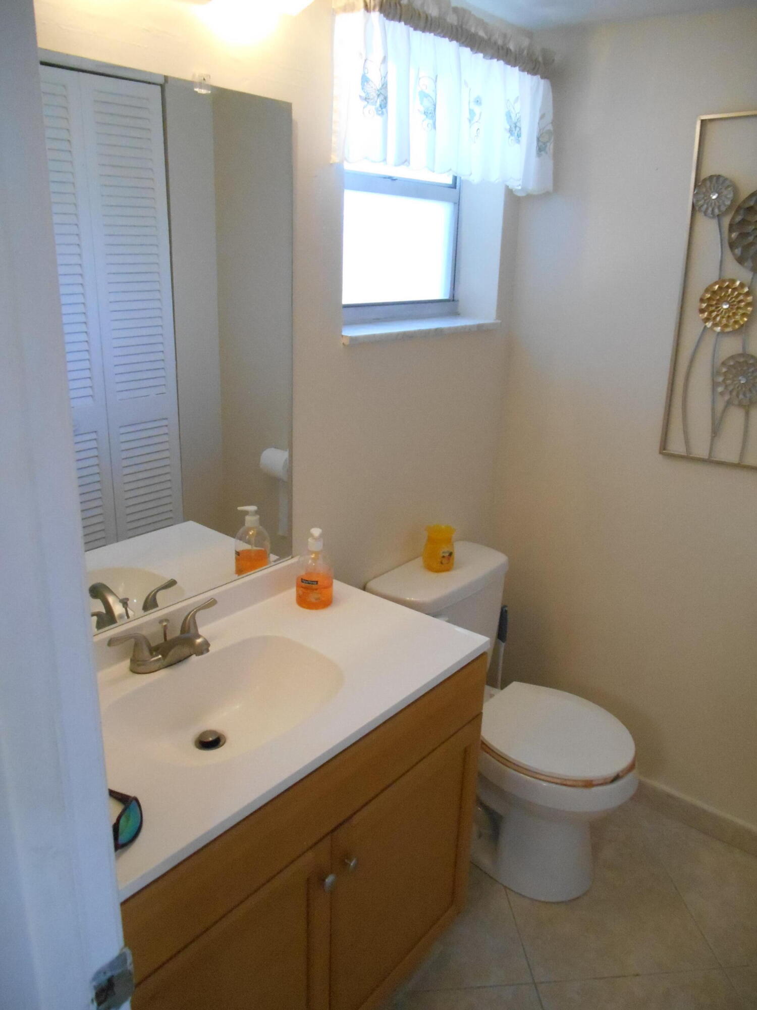 2615 Northeast 1st Court, Unit 301 Boynton Beach, FL 33435 - Photo 17 of 40 a bathroom with a sink a toilet and mirror