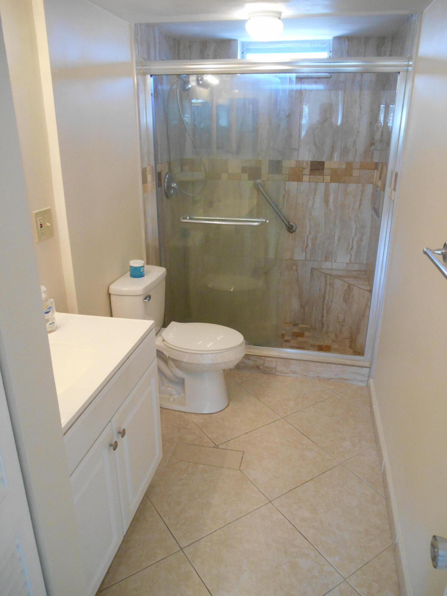 2615 Northeast 1st Court, Unit 301 Boynton Beach, FL 33435 - Photo 24 of 40 a bathroom with a shower a toilet and a sink