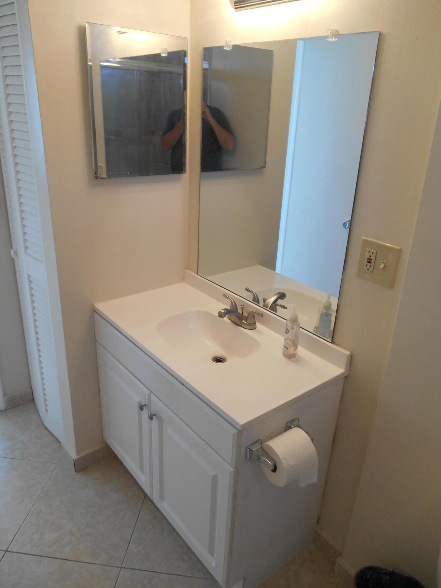 2615 Northeast 1st Court, Unit 301 Boynton Beach, FL 33435 - Photo 27 of 40 a bathroom with a sink and mirror
