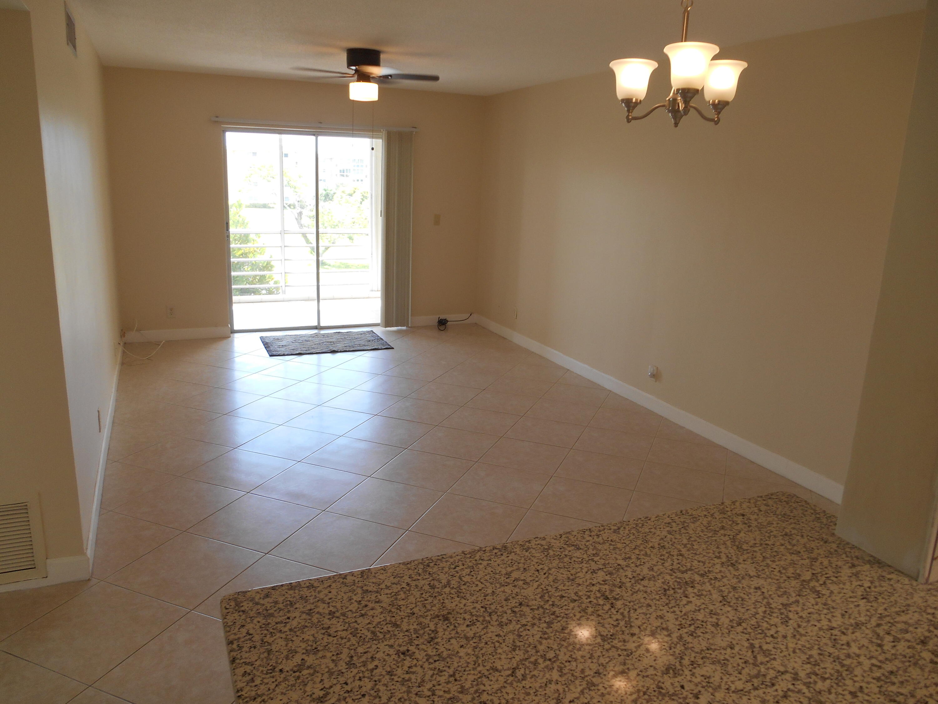 2615 Northeast 1st Court, Unit 301 Boynton Beach, FL 33435 - Photo 9 of 40 en empty room with windows and ceiling fan