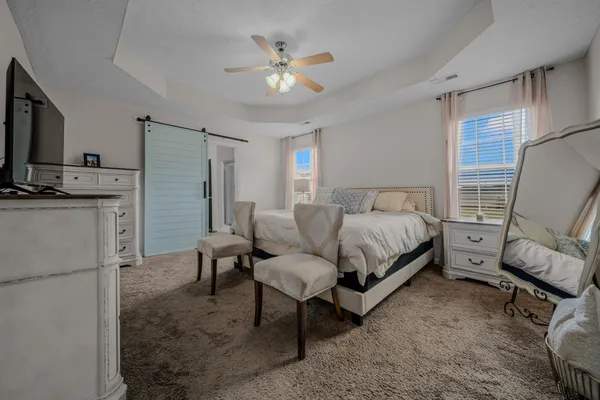 a bedroom with a bed a couch and a flat screen tv