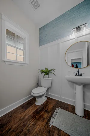 a bathroom with a toilet a sink and mirror