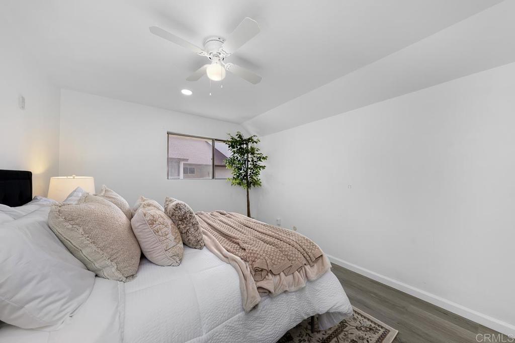 6131 Rancho Mission Road, Unit 211 San Diego, CA 92108 - Photo 14 of 21 a bedroom with a bed and a chandelier