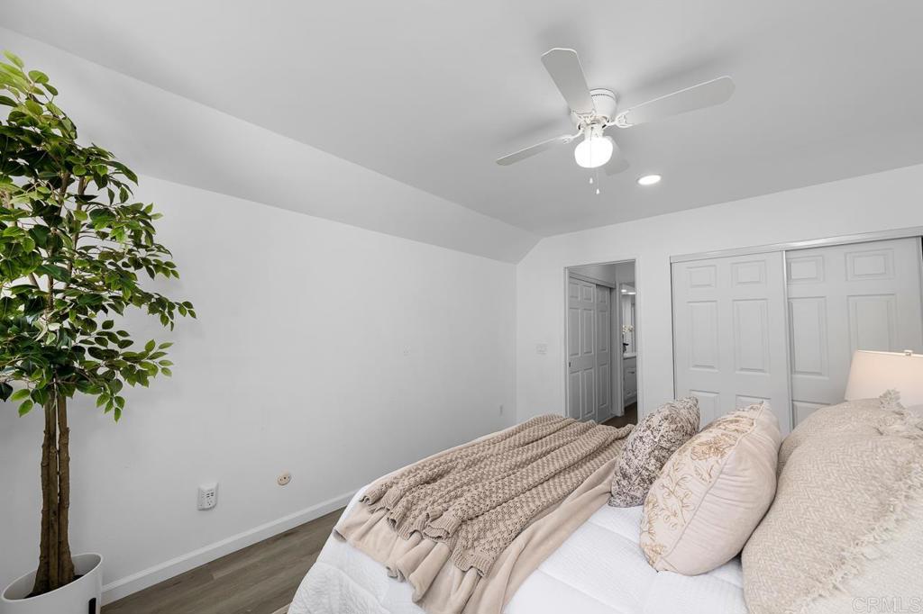6131 Rancho Mission Road, Unit 211 San Diego, CA 92108 - Photo 15 of 21 a bedroom with a bed and a potted plant