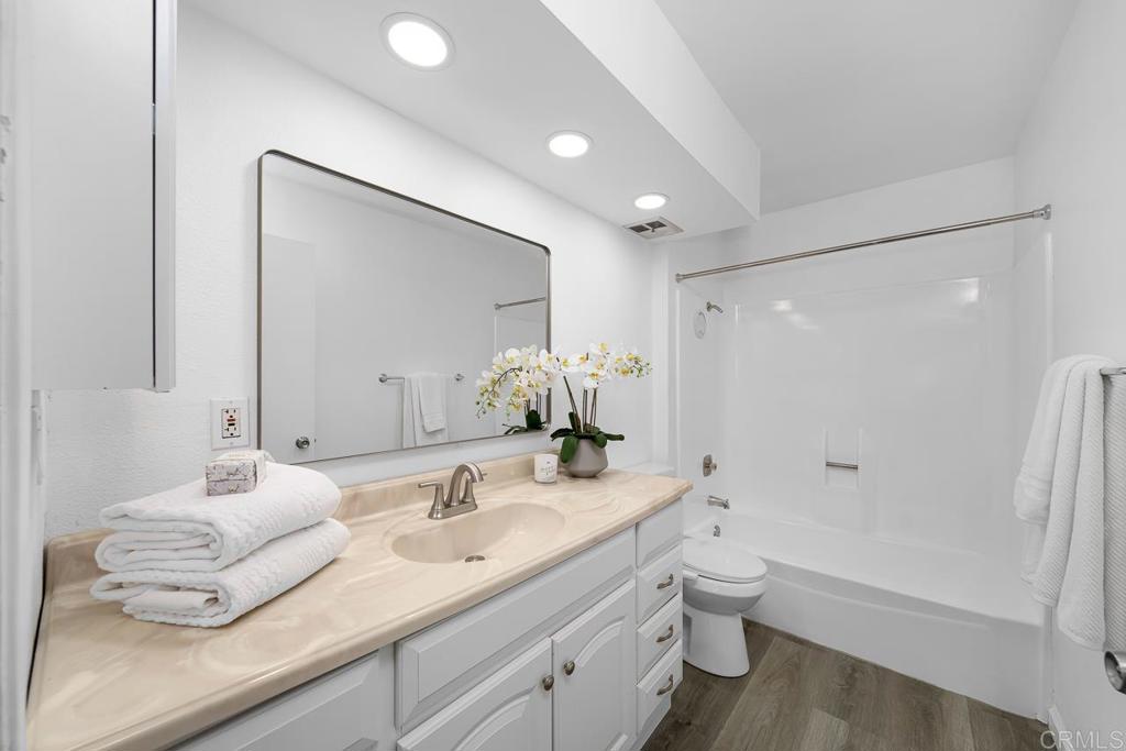 6131 Rancho Mission Road, Unit 211 San Diego, CA 92108 - Photo 16 of 21 a bathroom with a double vanity sink toilet and shower
