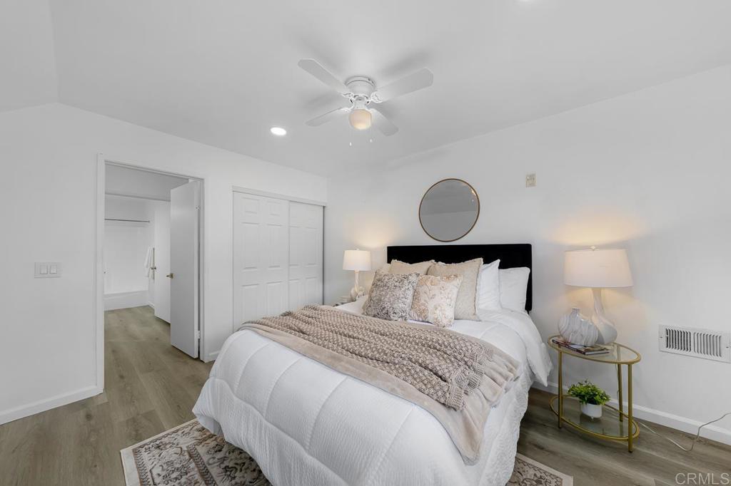 6131 Rancho Mission Road, Unit 211 San Diego, CA 92108 - Photo 4 of 21 a bedroom with a bed and a lamp with wooden floor