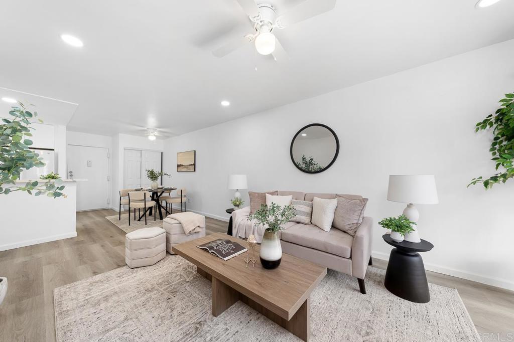 6131 Rancho Mission Road, Unit 211 San Diego, CA 92108 - Photo 7 of 21 a living room with furniture a chandelier and a potted plant