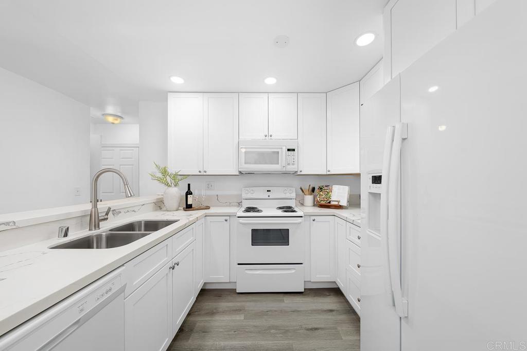 6131 Rancho Mission Road, Unit 211 San Diego, CA 92108 - Photo 9 of 21 a kitchen with white cabinets stainless steel appliances and sink