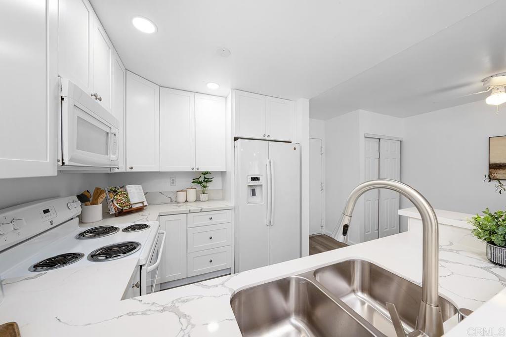6131 Rancho Mission Road, Unit 211 San Diego, CA 92108 - Photo 10 of 21 a kitchen with white cabinets and sink