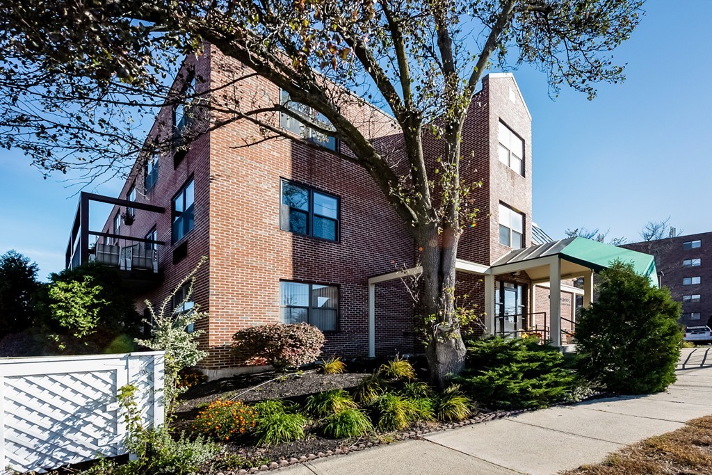 605 Eastern Avenue, Unit 211 Lynn, MA 01902 - Photo 3 of 3 a front view of a house with a garden