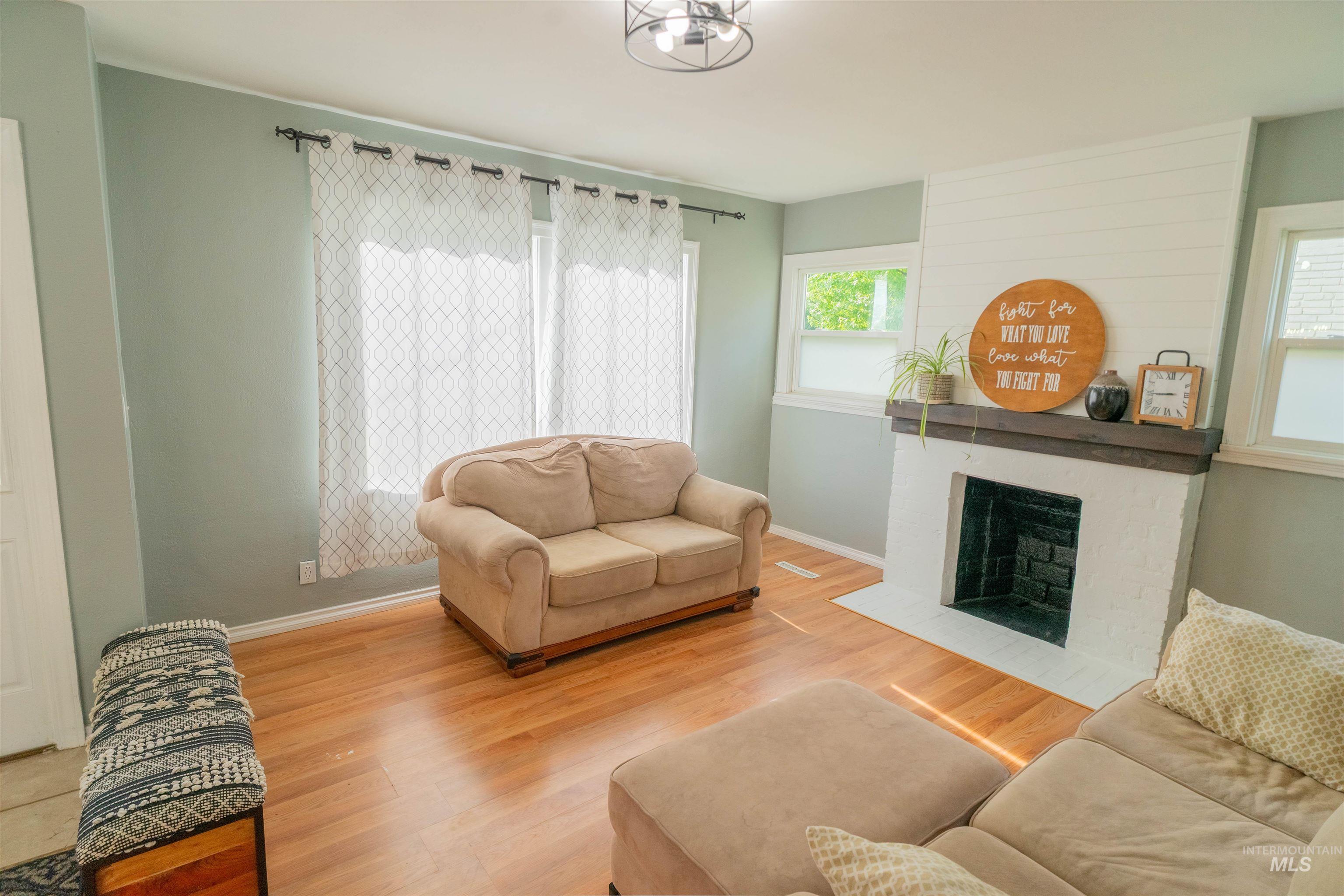 1212 14th Street Lewiston, ID 83501 - Photo 7 of 50 Living area with wood finished floors and a brick fireplace