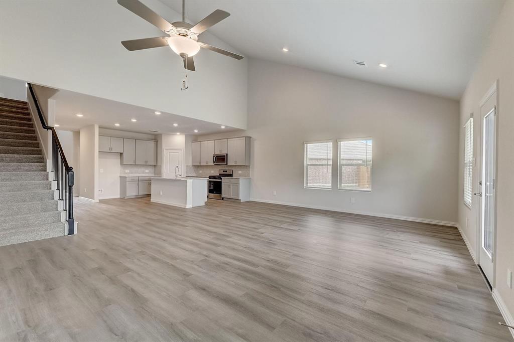 1405 Winters Way McKinney, TX 75071 - Photo 14 of 32 Unfurnished living room with high vaulted ceiling, light hardwood / wood-style floors, and ceiling fan