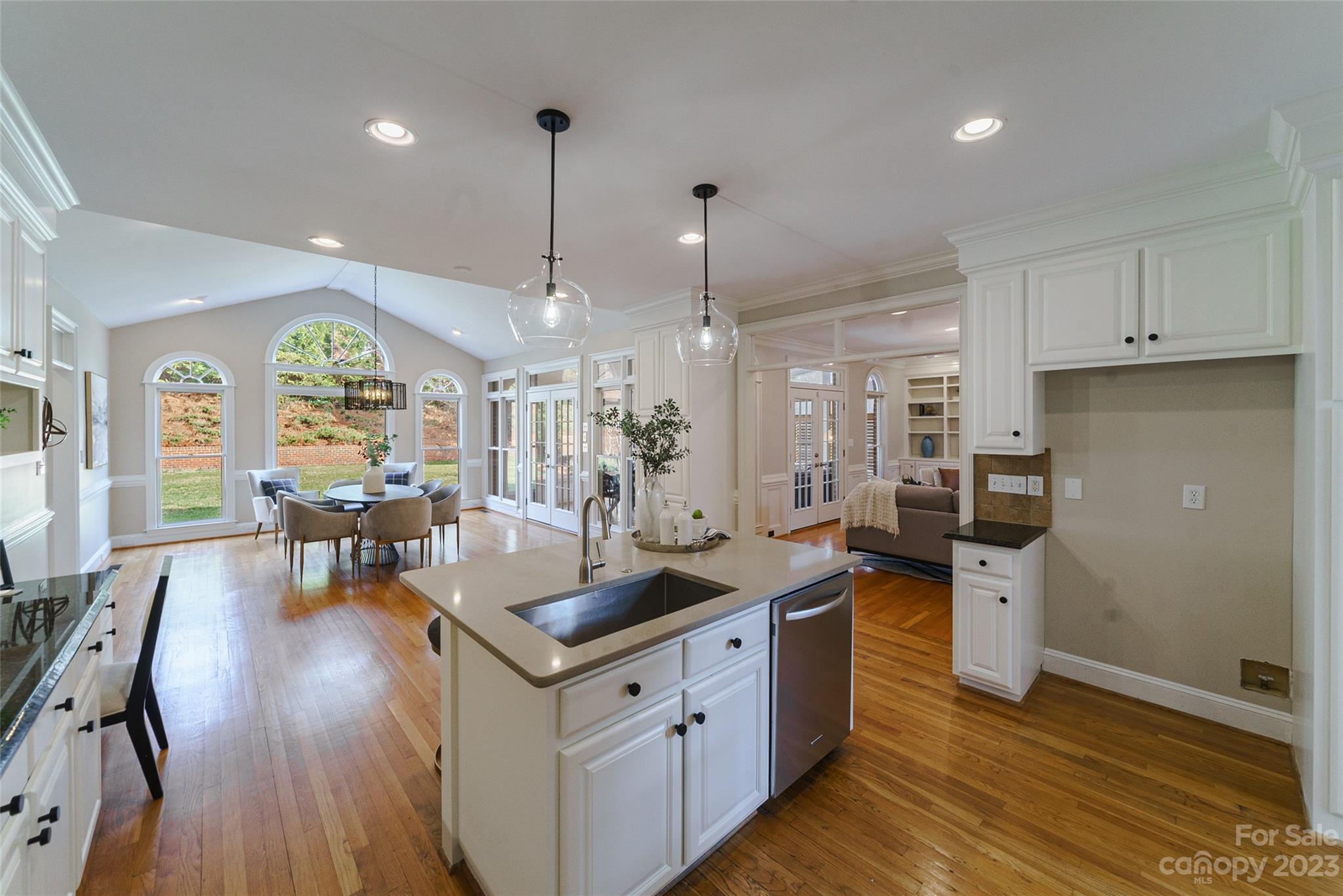 2134 Glade Hill Road Charlotte, NC 28270 - Photo 7 of 48 a kitchen with stainless steel appliances granite countertop a stove refrigerator a dining table and chairs with wooden floor