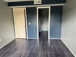 an empty room with wooden floor and closet