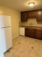 a view of kitchen with granite countertop cabinets and refrigerator