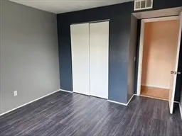 an empty room with wooden floor and closet