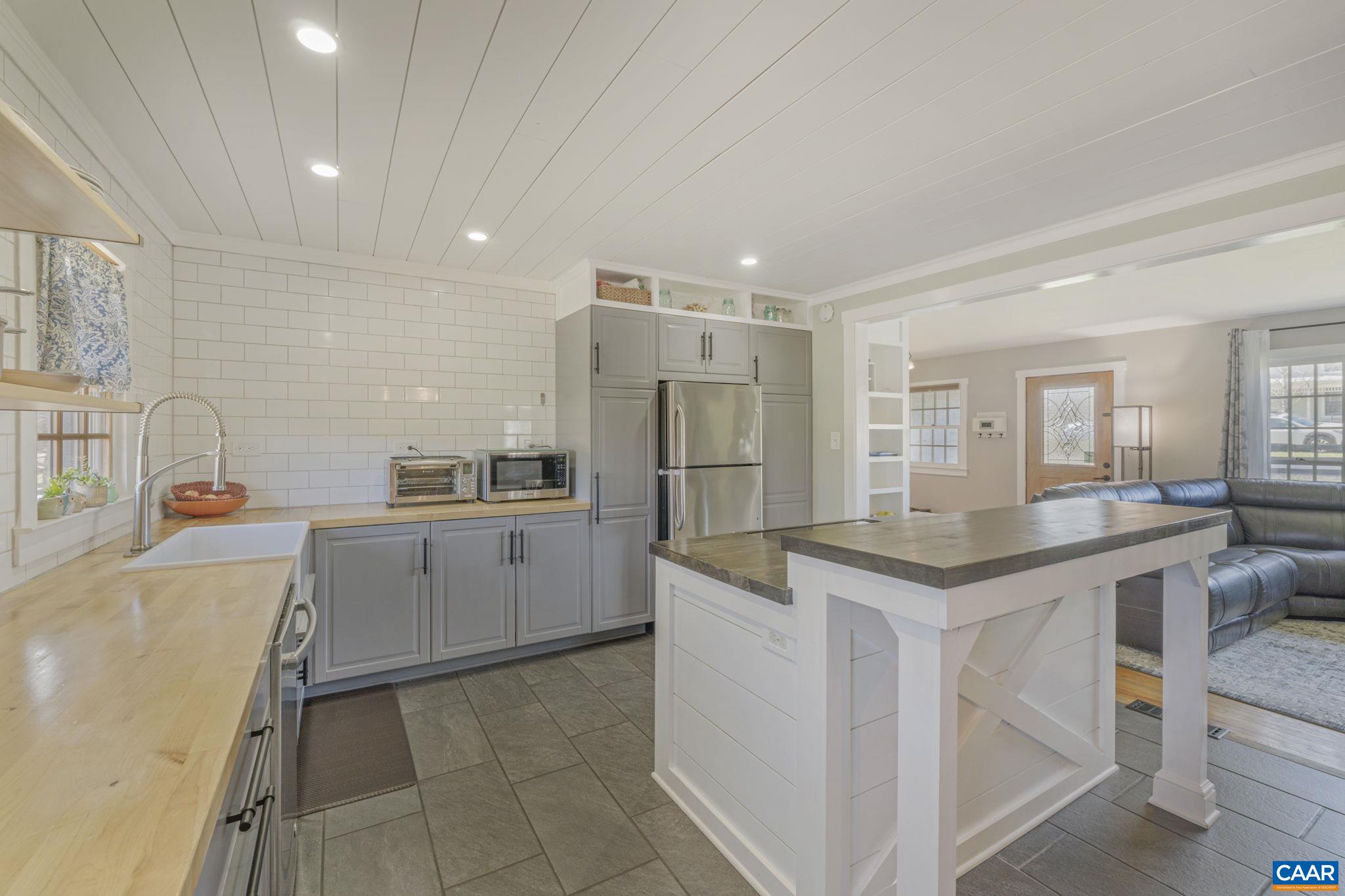 286 Madison Road Stanardsville, VA 22973 - Photo 3 of 48 a kitchen with a sink a refrigerator and white cabinets