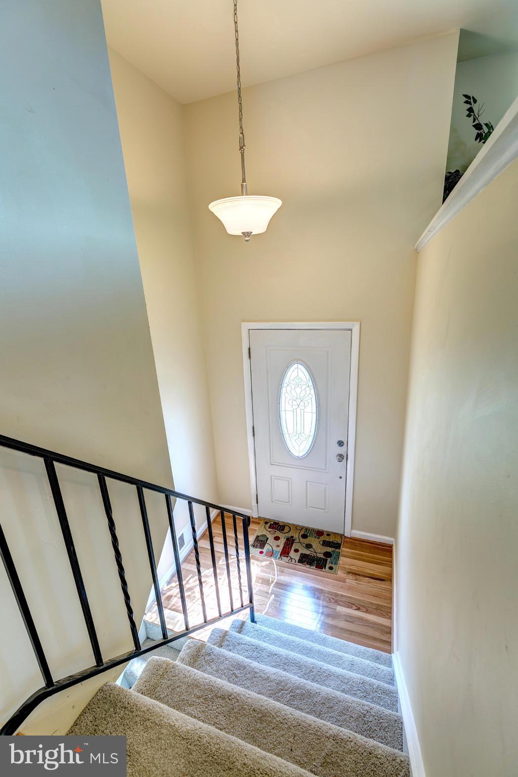 6711 Fox Meadow Road Baltimore, MD 21207 - Photo 12 of 30 a view of a hallway with wooden floor and a chandelier