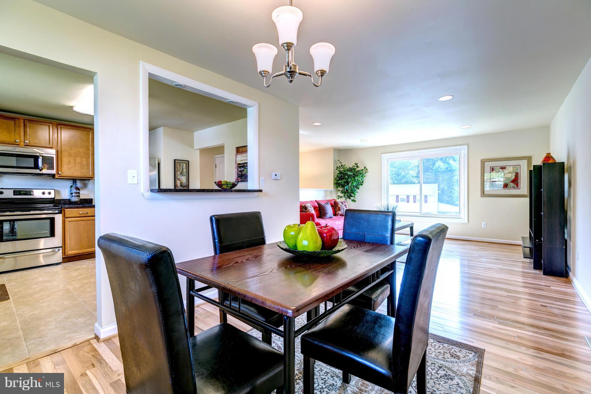 6711 Fox Meadow Road Baltimore, MD 21207 - Photo 8 of 30 a view of a dining room with furniture a chandelier and wooden floor