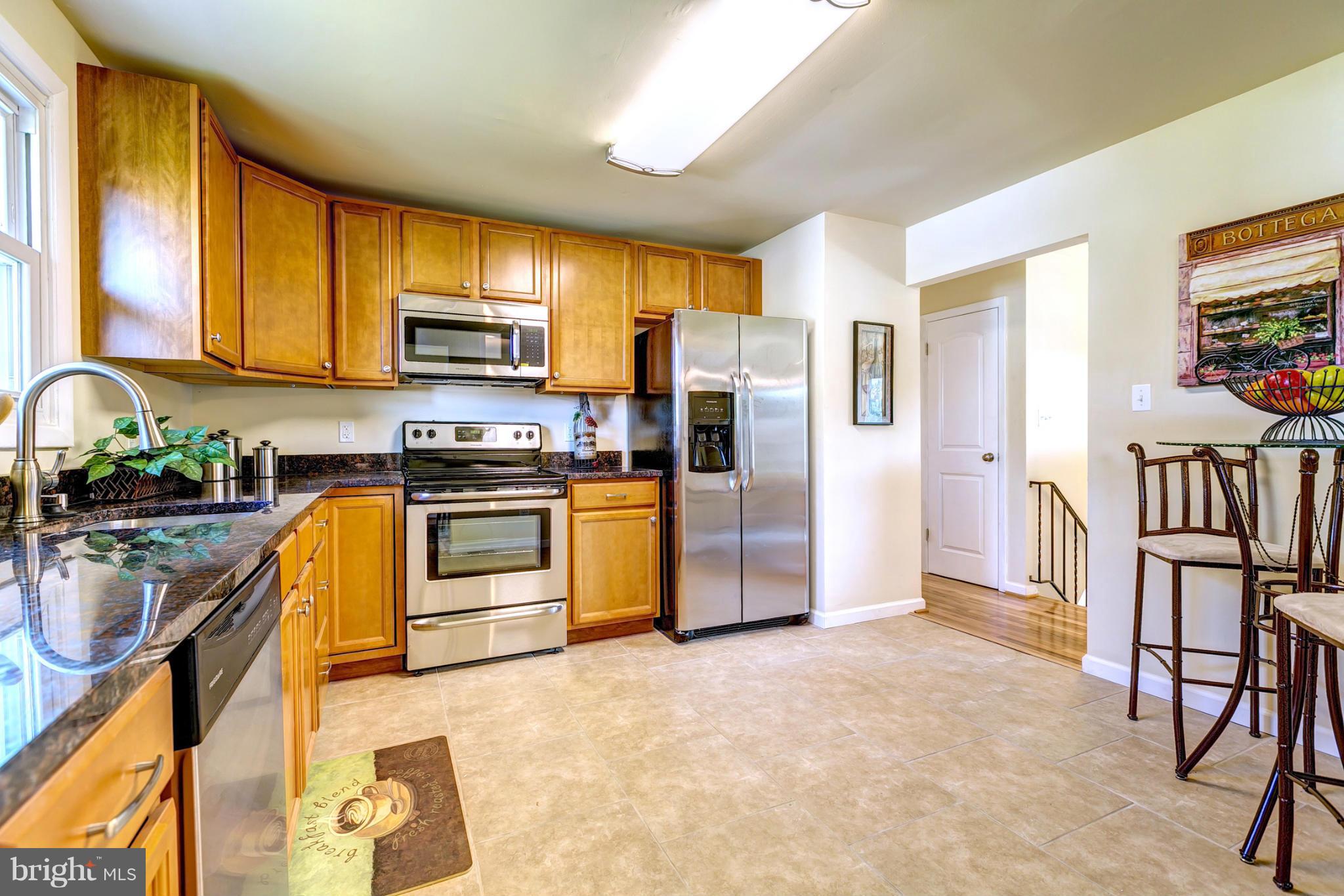 6711 Fox Meadow Road Baltimore, MD 21207 - Photo 9 of 30 a kitchen with stainless steel appliances a refrigerator sink and stove