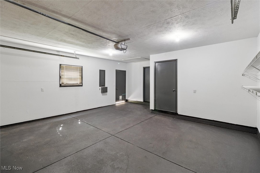 3930 Wood Road Madison, OH 44057 - Photo 40 of 45 Garage featuring electric panel and a garage door opener