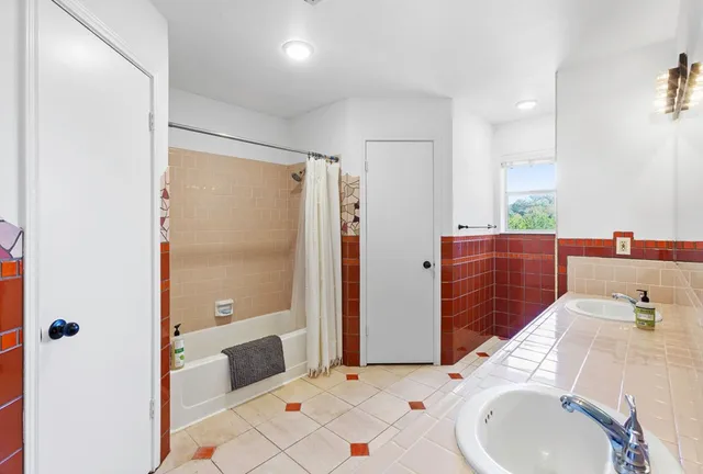 a bathroom with a sink mirror and shower