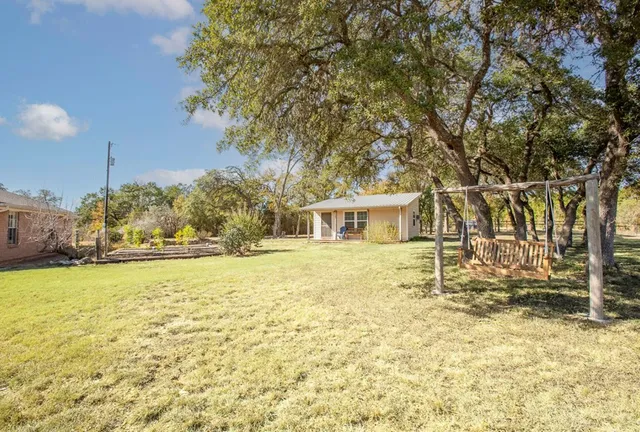 a view of a house with backyard and sitting area