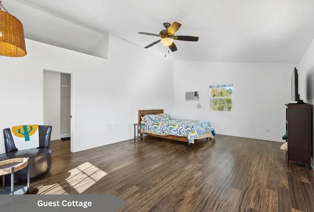 a living room with a bed furniture and next to a window