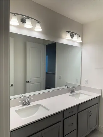 a bathroom with a double vanity sink and a mirror