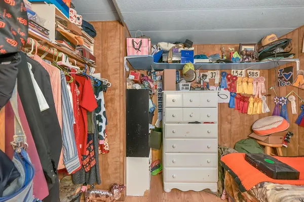 a view of walk in closet with clothes and shoes