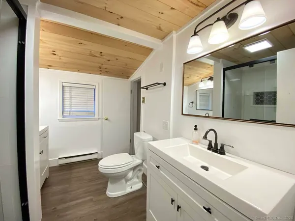 a bathroom with a toilet a sink and mirror