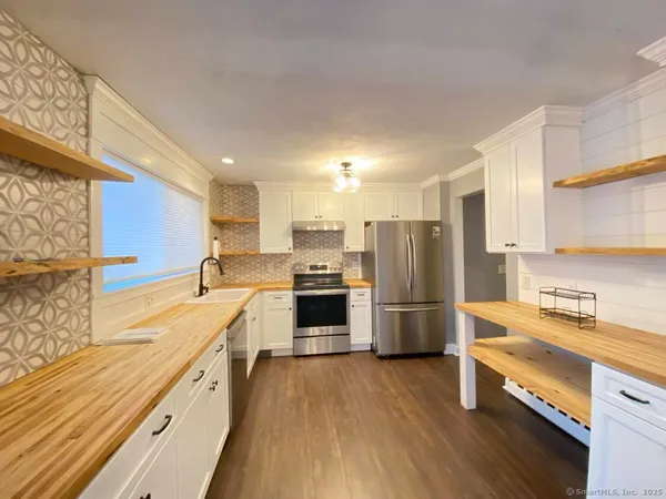 a large kitchen with a large counter top appliances and cabinets