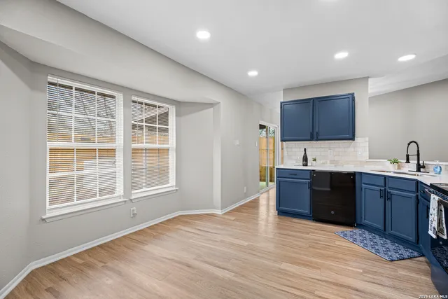 a large kitchen with stainless steel appliances granite countertop a sink and wooden cabinets