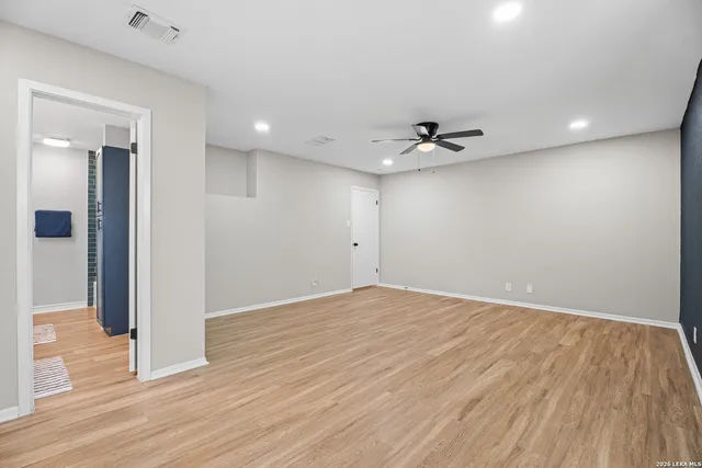 a view of an empty room with wooden floor
