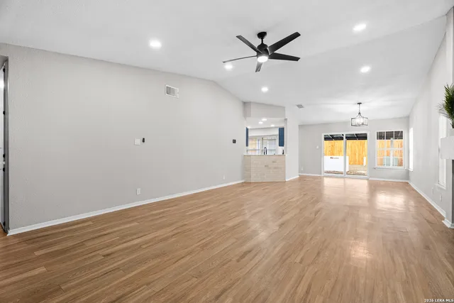 an empty room with a window and wooden floor